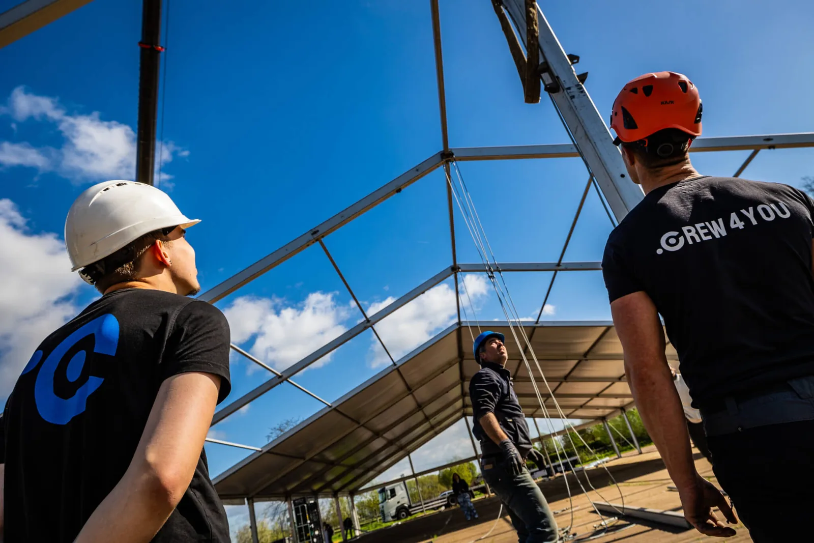 Tentenbouwers van Crew-4You met helm bouwen een aluhal op